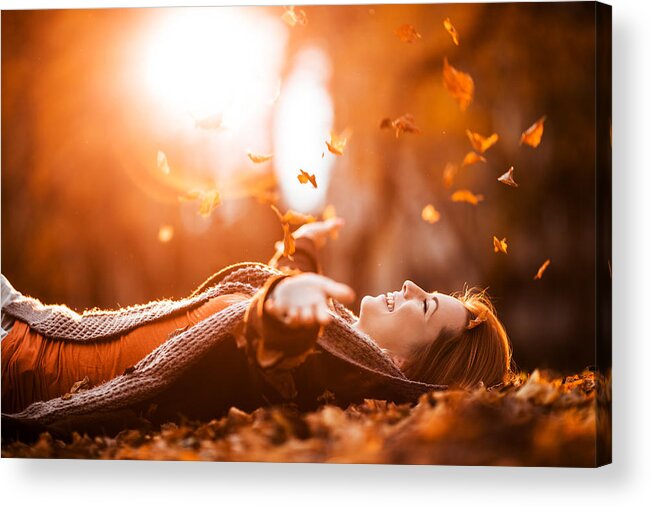 Human Arm Acrylic Print featuring the photograph Carefree woman relaxing and throwing autumn leaves in nature. by BraunS