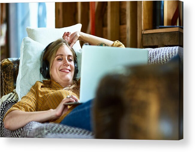 Tranquility Acrylic Print featuring the photograph Cheerful mid adult woman using laptop and smiling with headphones by 10'000 Hours