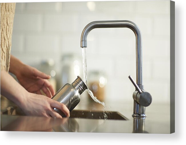 Environmental Conservation Acrylic Print featuring the photograph Cleaning a plastic free reusable water bottle in kitchen sink. by Dougal Waters