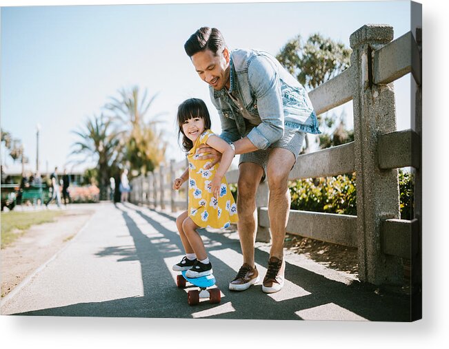 Child Acrylic Print featuring the photograph Father Helps Young Daughter Ride Skateboard by RyanJLane