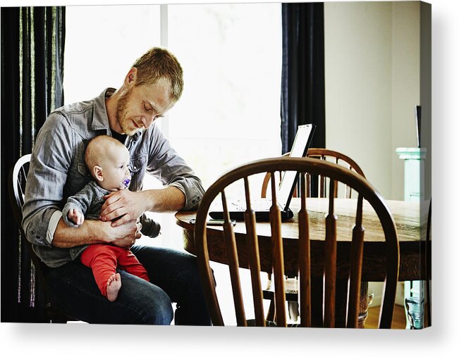 People Acrylic Print featuring the photograph Father holding baby girl on lap at dining table by Thomas Barwick