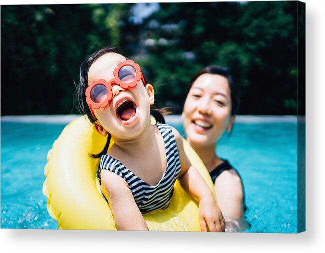 Toddler Acrylic Print featuring the photograph Happy Asian toddler girl with sunglasses smiling joyfully and enjoying family bonding time with mother having fun in the swimming pool in summer by D3sign