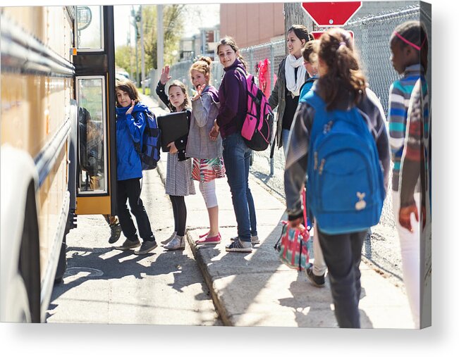 White People Acrylic Print featuring the photograph Kids in line waiting to get on school bus saying goodbye. by Martinedoucet