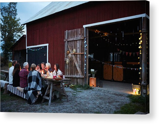 Mature Adult Acrylic Print featuring the photograph Male and female friends enjoying dinner party against barn at farm by Maskot