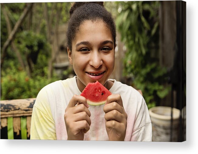 Diversity Acrylic Print featuring the photograph Mixed-race teenage girl with braces eating watermelon in backyard. by Martinedoucet