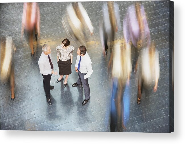Working Acrylic Print featuring the photograph People rushing past business people talking by Daly and Newton
