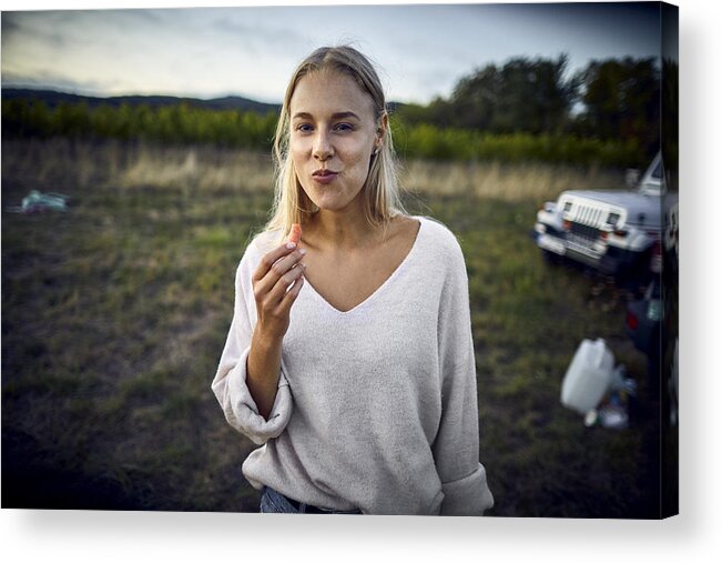 Camping Acrylic Print featuring the photograph Portrait of young woman eating a carrot in the countryside by Oliver Rossi