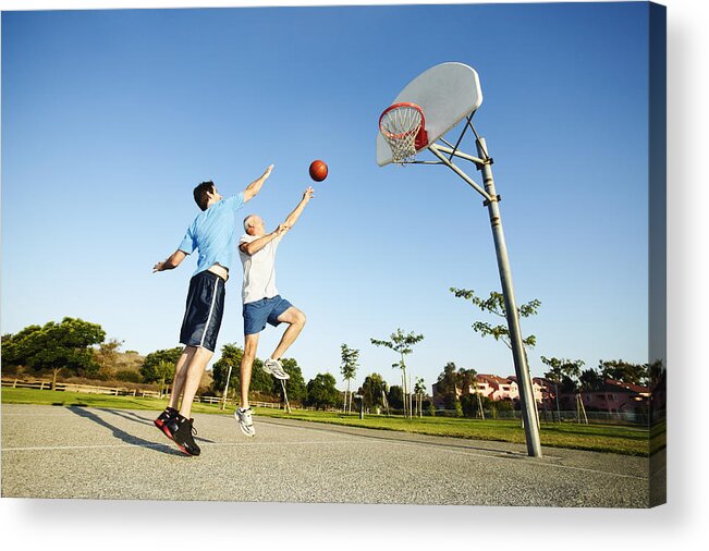 Young Men Acrylic Print featuring the photograph Senior man and young man playing basketball on outdoor court by Peter Griffith