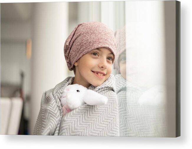 Headwear Acrylic Print featuring the photograph Smiling girl with cancer looks out window by FatCamera