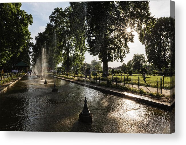 In A Row Acrylic Print featuring the photograph Spraying fountains in park pond by Jeremy Woodhouse