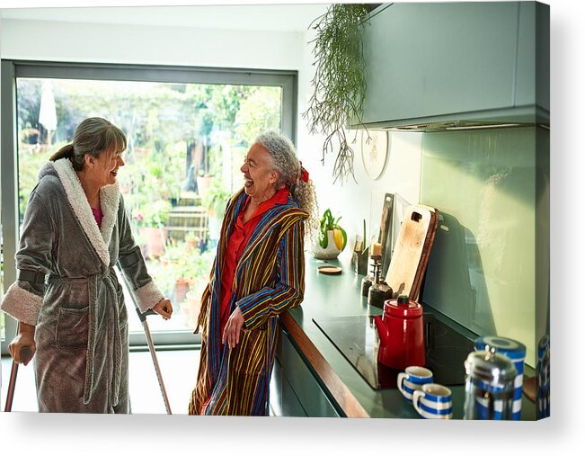 Breakfast Acrylic Print featuring the photograph Two flatmates laughing and smiling in kitchen by 10'000 Hours