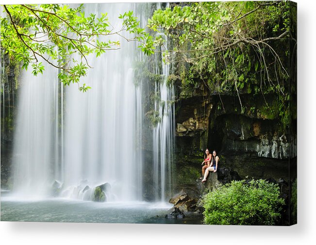 Outdoors Acrylic Print featuring the photograph Two women relaxing next to a waterfall. by OGphoto