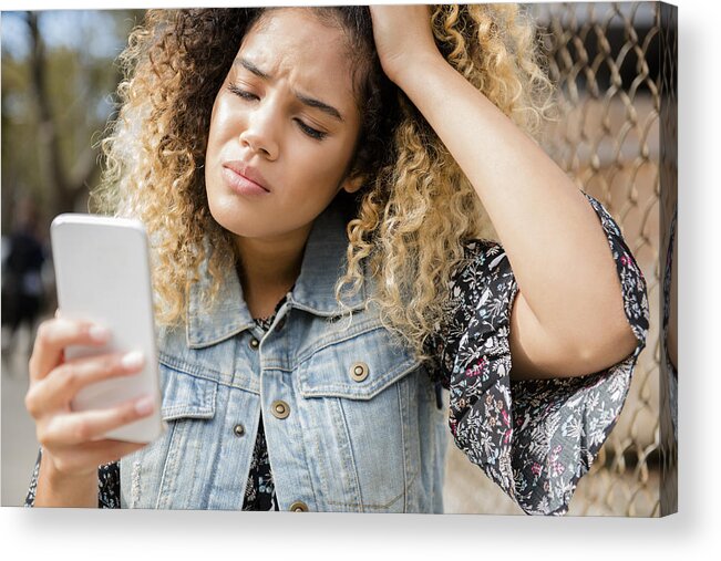 Problems Acrylic Print featuring the photograph Unhappy Mixed Race woman texting on cell phone by JGI/Jamie Grill