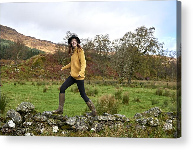 Scenics Acrylic Print featuring the photograph Woman walking along stone wall by Plume Creative