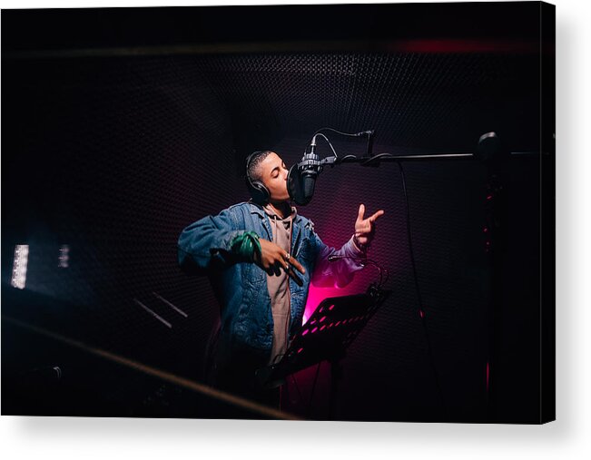 Performer Acrylic Print featuring the photograph Young hipster African-American rapper recording songs in music recording studio by Wundervisuals