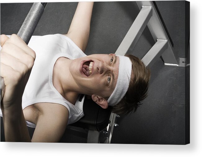 Focus Acrylic Print featuring the photograph Young man lifting weight, overhead view, close-up by Holloway