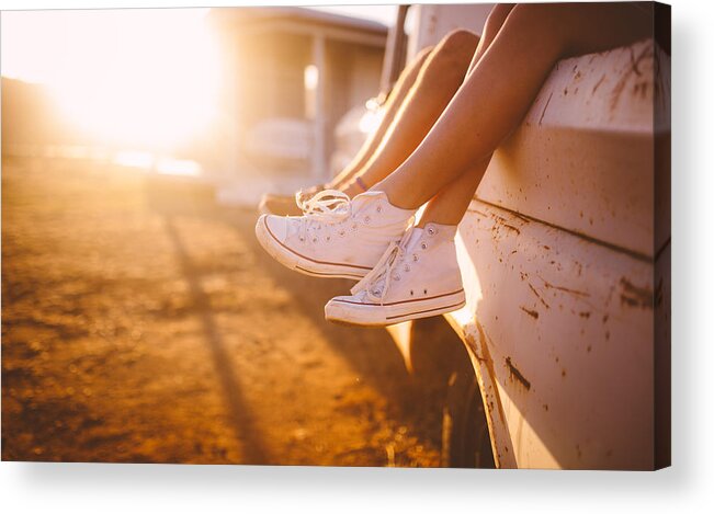 Heterosexual Couple Acrylic Print featuring the photograph Teen couple's legs hanging out of vehicle with sun flare by Wundervisuals