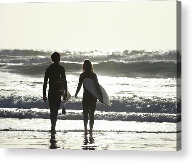 Young Men Acrylic Print featuring the photograph Couple Walking Out To Sea With by Dougal Waters