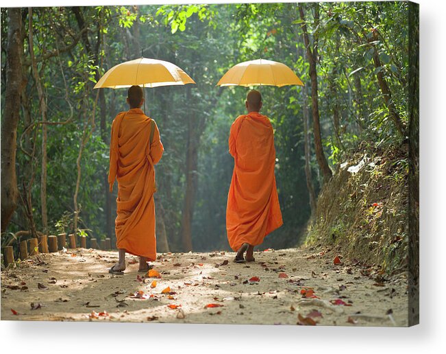 Young Men Acrylic Print featuring the photograph Buddhist Monks Walking Along Dirt Road by Martin Puddy