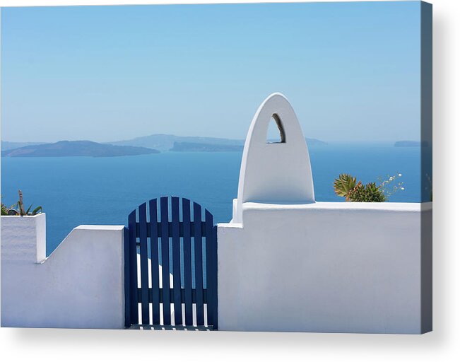Sidewalk Acrylic Print featuring the photograph Facade Of Brick Fence Or Small White Wall With A Blue Gate To Enter Or Exit And A White Chimney Without Smoke With The Blue Aegean Sea At The Back In The Idyllic Island Of Santorini In Greece by Cavan Images