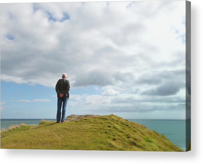 Tranquility Acrylic Print featuring the photograph Man Standing Alone On A Hill Staring At by Ken Welsh / Design Pics