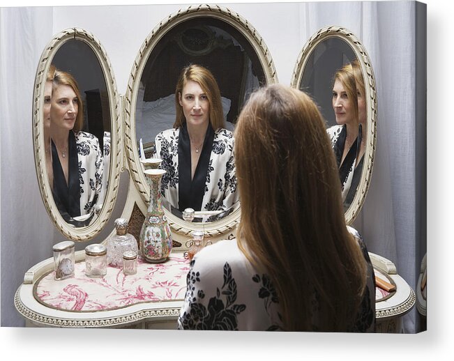 Caucasian Ethnicity Acrylic Print featuring the photograph Mature woman looking at reflection in bedside mirror by Betsie Van der Meer