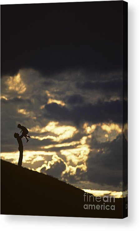 Silhouetted Acrylic Print featuring the photograph Father holding daughter above his head along hillside silhouette by Jim Corwin