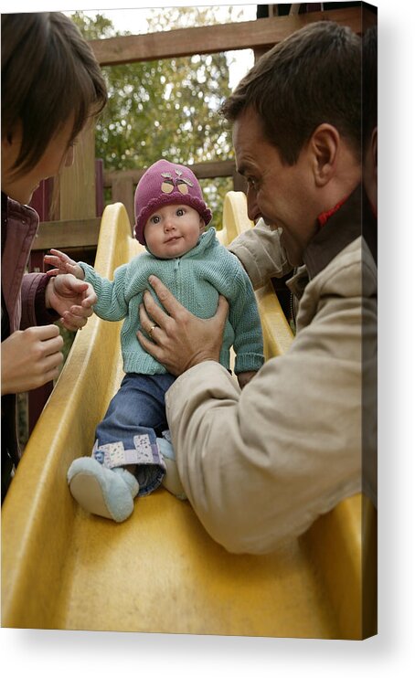 Mid Adult Women Acrylic Print featuring the photograph Parents with baby playing on slide by Comstock Images