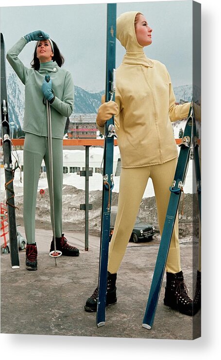 Two People Acrylic Print featuring the photograph Two Models At A Ski Resort Wearing Outfits by Frances McLaughlin-Gill