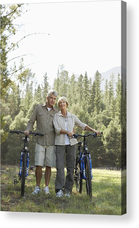 Heterosexual Couple Acrylic Print featuring the photograph Senior Couple Standing Side by Side With Their Bikes With Woodland in the Background by Dylan Ellis