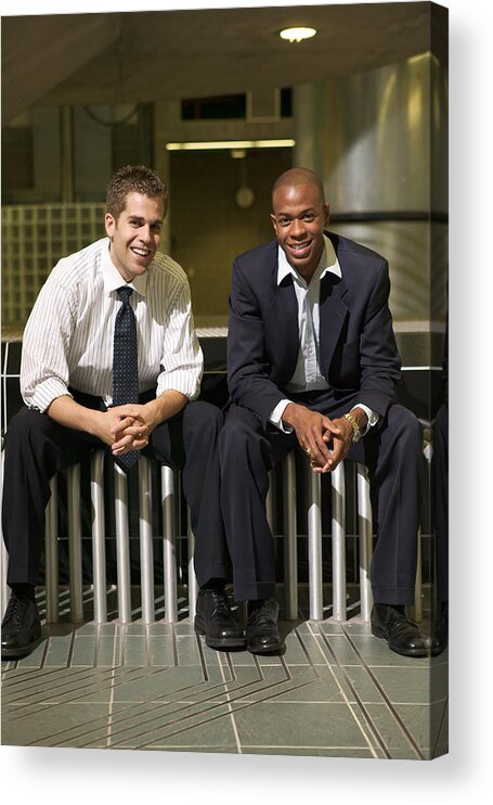 Corporate Business Acrylic Print featuring the photograph Two Young Business Men Sit And Smile On A Bench In Their Office Atrium by Photodisc