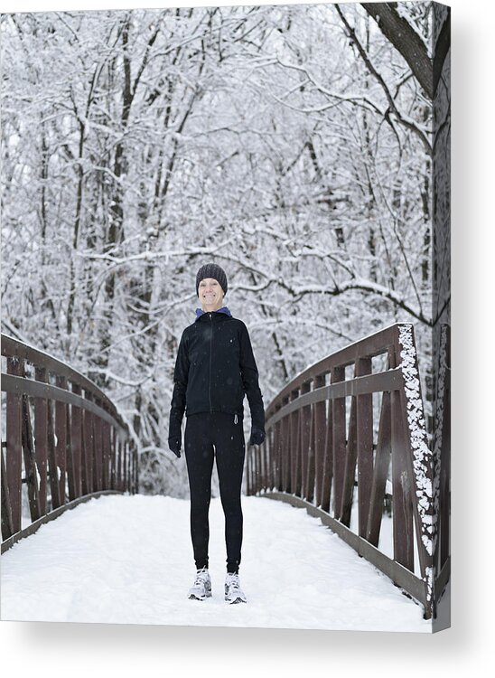 Mature Adult Acrylic Print featuring the photograph Woman dressed for winter running on snowy bridge by Tony Anderson