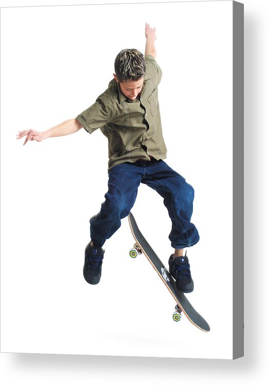 Recreational Pursuit Acrylic Print featuring the photograph A Young Caucasian Boy Does Tricks On His Skateboard by Photodisc