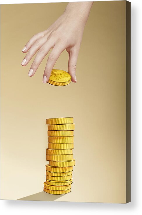 Coin Acrylic Print featuring the photograph Hand putting paper gold coin on stack of coins by Paper Boat Creative