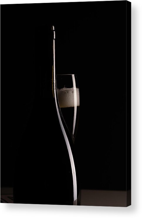 Red Wine Acrylic Print featuring the photograph Red sparking wine on a wineglass and black wine bottle. by Michalakis Ppalis