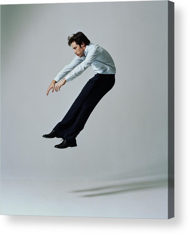 Human Arm Acrylic Print featuring the photograph Young businessman flying backwards, side view #1 by PM Images