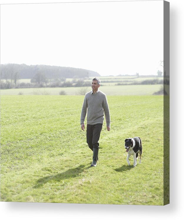 Pets Acrylic Print featuring the photograph Man walking in countryside with pet dog by Dougal Waters