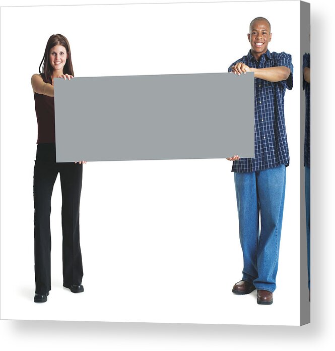 Young Men Acrylic Print featuring the photograph A Young Attractive Caucasian Woman And A Young African American Man Hold Up A Large Sign Together And Smile by Photodisc
