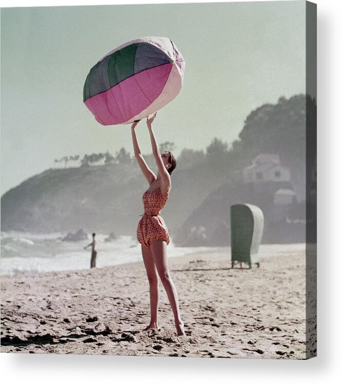 Fashion Acrylic Print featuring the photograph A Model Wearing A Bathing Suit Holding Up An by Richard Rutledge