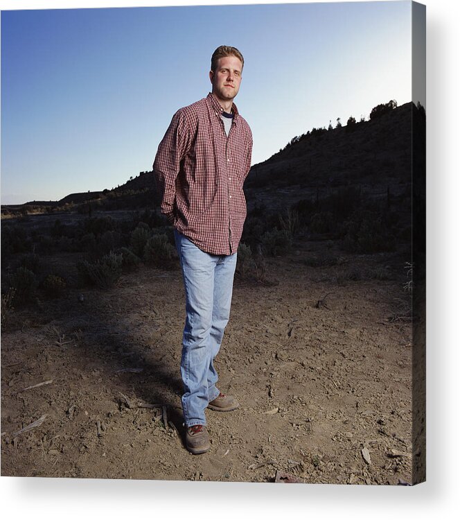 One Man Only Acrylic Print featuring the photograph Young Caucasian Man With Jeans And Red Long Sleeved Shirt Stands Outdoors Looking Into The Camera by Photodisc