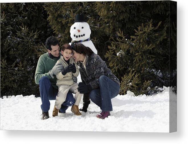 4-5 Years Canvas Print featuring the photograph Family with snowman #1 by Comstock Images