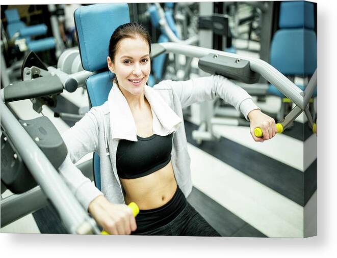 One Person Canvas Print featuring the photograph Woman Using Shoulder Press Machine #1 by Science Photo Library
