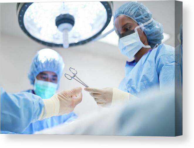 Indoors Canvas Print featuring the photograph Nurse Passing Surgical Scissors To Surgeon #2 by Science Photo Library