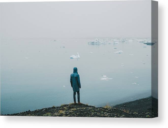 Tranquility Canvas Print featuring the photograph Man walking near Jokulsarlon lagoon #3 by Oleh_Slobodeniuk