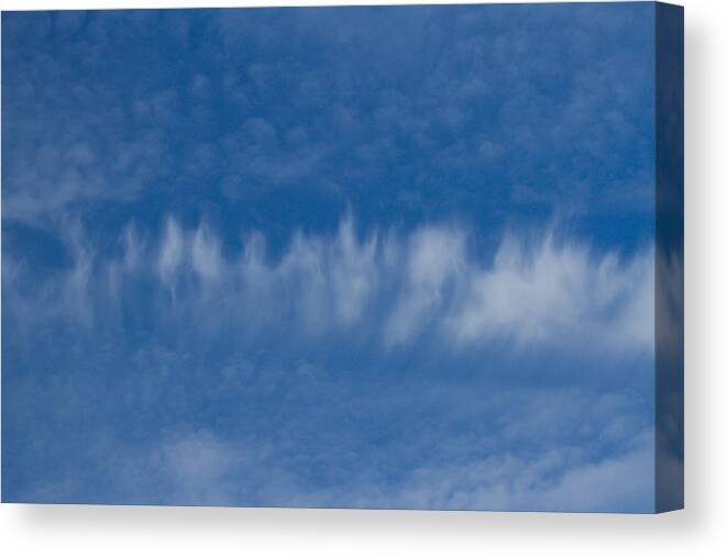 Clouds Canvas Print featuring the photograph A batch of interesting clouds in a blue sky by Eti Reid
