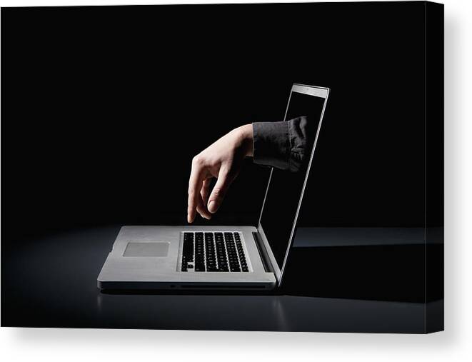 Shadow Canvas Print featuring the photograph A hand reaching through a laptop to type on the keyboard by fStop Images - Epoxydude