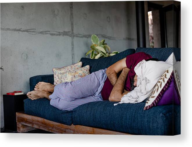 Cold And Flu Canvas Print featuring the photograph A man lying down on a sofa, sleeping by Photographer, Basak Gurbuz Derman