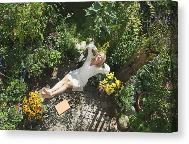Hands Behind Head Canvas Print featuring the photograph Austria, Salzburger Land, Young woman in garden, relaxing, elevated view by Hans Huber