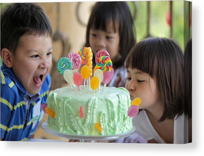 4-5 Years Canvas Print featuring the photograph Boy and girl making scarily hungry face on cake by Susan.k.