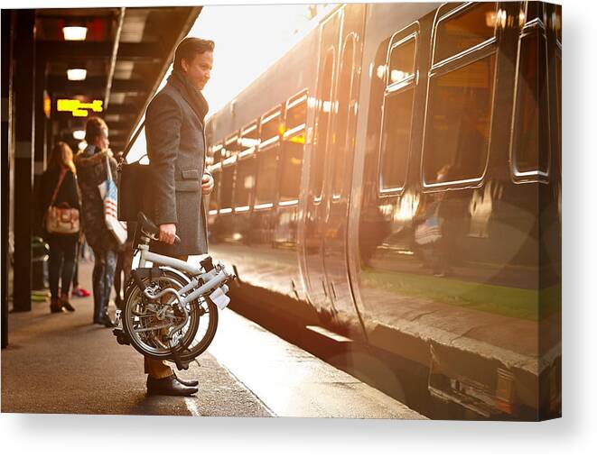 People Canvas Print featuring the photograph Businessman with folding cycle boarding train by Dean Mitchell